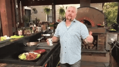Man In Blue And White Striped Shirt Cooking In Kitchen GIF