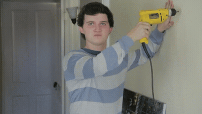 Man In Blue And White Striped Shirt Using Yellow Drill GIF