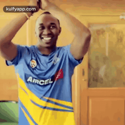 Man In Blue And Yellow Aircel Shirt Standing In Front Of Door GIF