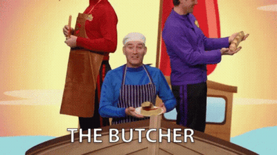 Man In Blue Apron Holding Plate With Butcher Text GIF