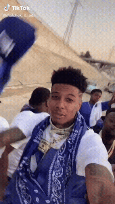 Man In Blue Bandana And White Shirt Standing Before Crowd GIF