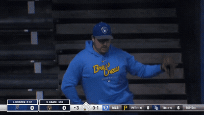 Man In Blue Brew Crew Sweatshirt In Front Of Scoreboard GIF
