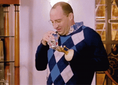 Man In Blue Checkered Sweater Drinking From Glass GIF