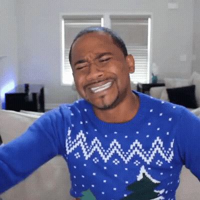 Man In Blue Christmas Sweater On Couch GIF