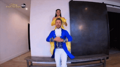 Man In Blue Coat Carrying Woman In Yellow Dress GIF