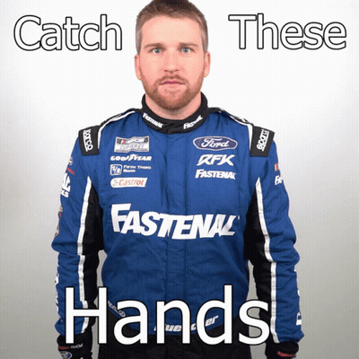 Man In Blue Fastenal Jacket And Catch These Hands Sign GIF