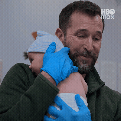 Man In Blue Gloves Holding Baby With HBO Max Background GIF