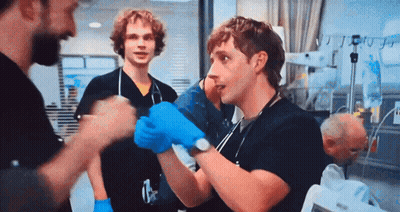 Man in Blue Gloves Talking in Hospital