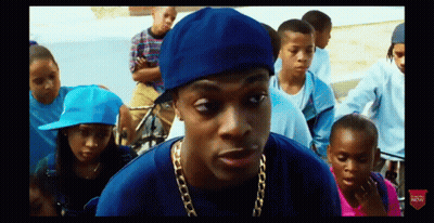 Man In Blue Hat And Gold Chain In Front Of Children GIF
