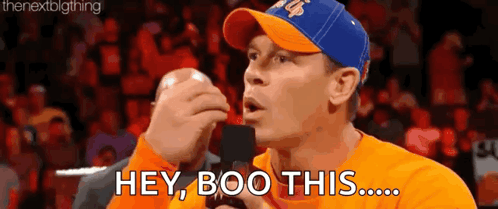 Man In Blue Hat And Orange Shirt Talking GIF