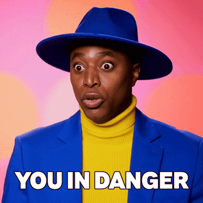 Man In Blue Hat And Yellow Turtleneck Saying You In Danger GIF