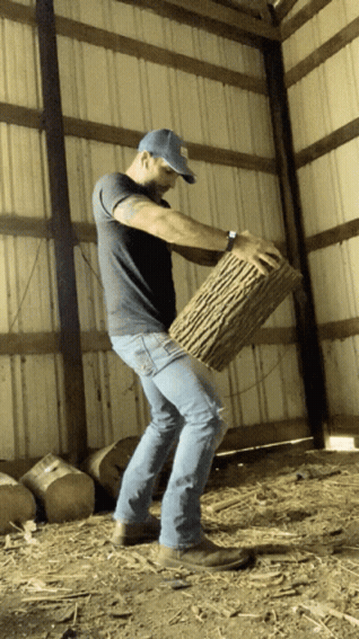 Man In Blue Hat Holding Log GIF