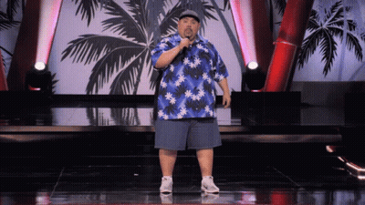 Man In Blue Hawaiian Shirt On Stage With Microphone GIF