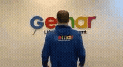 Man In Blue Hoodie In Front Of Gerar Sign GIF