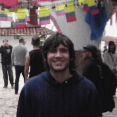 Man In Blue Hoodie Smiling In Crowd GIF