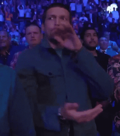 Man In Blue Jacket Applauding In Crowd GIF