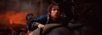 Man In Blue Jacket Crawling Through Rocks GIF