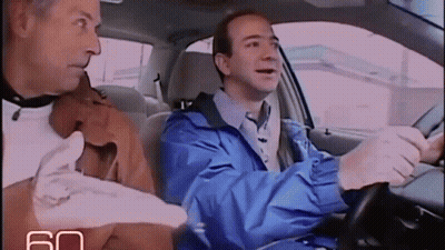 Man In Blue Jacket Driving Car Next To Man In Brown Jacket GIF