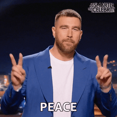 Man In Blue Jacket Giving Peace Sign GIF