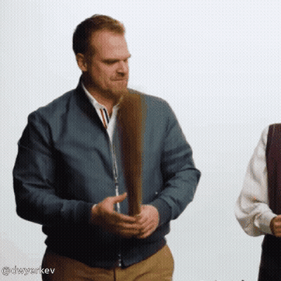 Man In Blue Jacket Holding Feather GIF