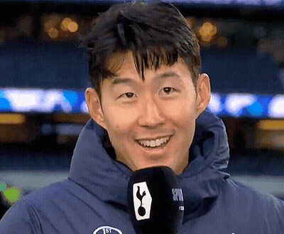 Man In Blue Jacket Holding Microphone With Tottenham Logo GIF