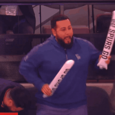 Man In Blue Jacket Holding Spurs Sign GIF