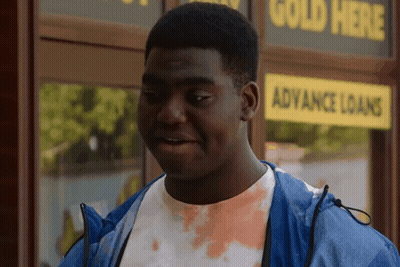 Man In Blue Jacket In Front Of Gold Loans Store GIF