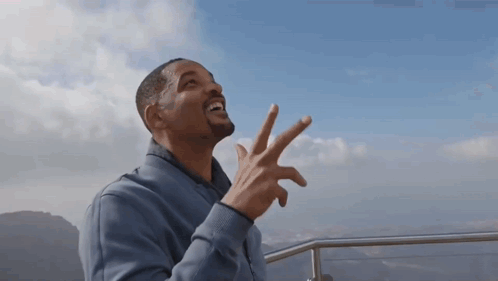 Man In Blue Jacket Making Peace Sign GIF