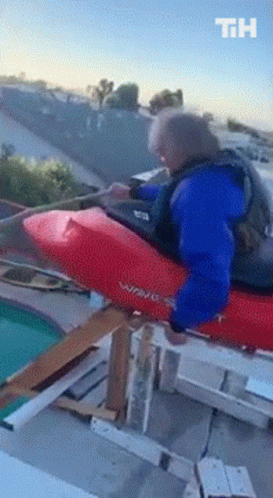 Man In Blue Jacket Riding Red Wave Kayak On Rooftop GIF