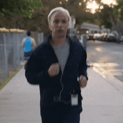 Man In Blue Jacket Running Down Sidewalk GIF
