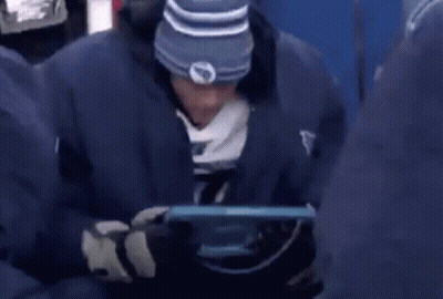 Man In Blue Jacket Saying Titans Looking At Tablet GIF