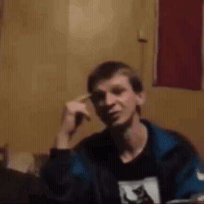 Man In Blue Jacket Sitting With Hand On Head GIF