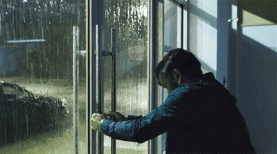 Man In Blue Jacket Standing In Front Of Glass Door GIF