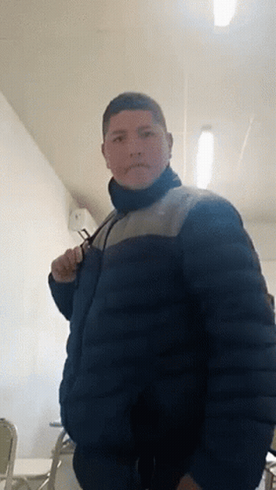 Man In Blue Jacket Standing In Room With Chairs GIF