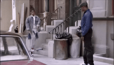 Man In Blue Jacket Standing Next To Trash Can GIF