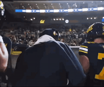 Man In Blue Jacket Talking To Football Player GIF