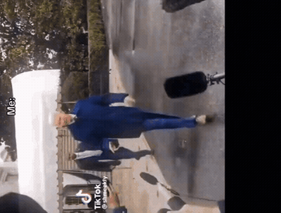 Man In Blue Jacket Walking Down Street GIF
