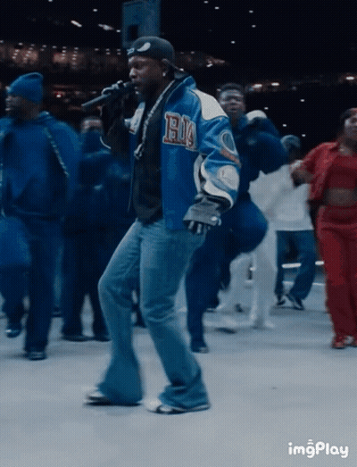 Man In Blue Jacket With Letter H In Front Of Crowd GIF