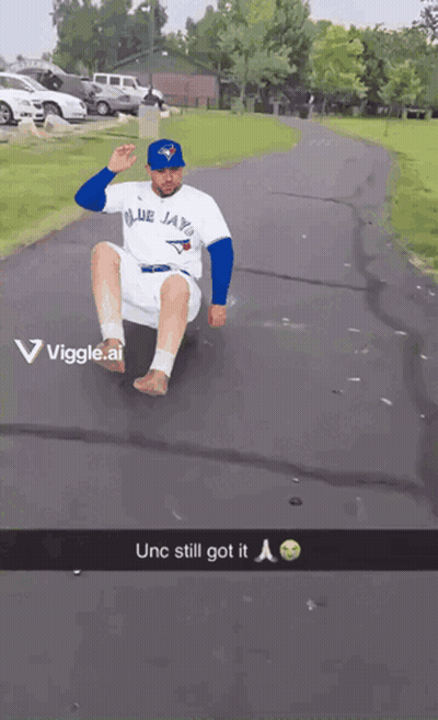 Man In Blue Jays Shirt Sliding Down Road GIF