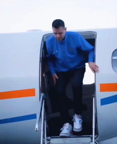 Man In Blue Jordan Sweatshirt Climbing Out Airplane GIF