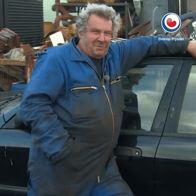 Man In Blue Jumpsuit Leaning Against Black Car Omrop Fryslan GIF