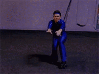 Man In Blue Jumpsuit Standing In Rain With Hands Up GIF