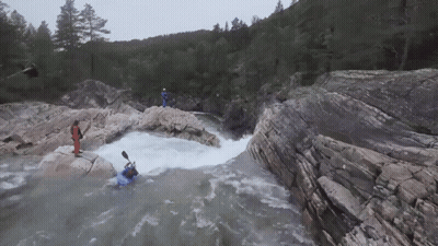 Man In Blue Kayak Going Through Waterfall GIF