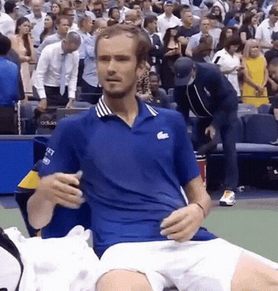 Man In Blue Lacoste Shirt Sitting On Tennis Court GIF