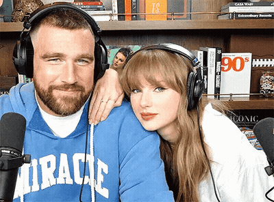 Man In Blue Miracle Sweatshirt With Woman Wearing Headphones And Microphone GIF