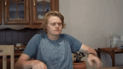 Man In Blue Nike Shirt Sitting At Kitchen Table GIF