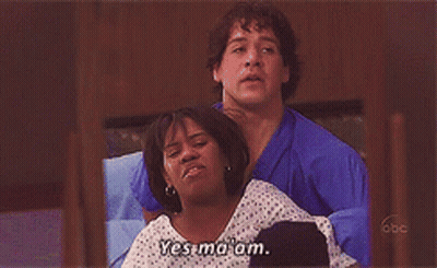 Man In Blue Scrub Holding Woman In Hospital Gown Saying Yes Ma'am GIF