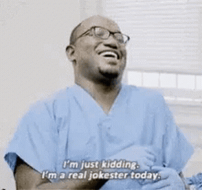 Man In Blue Scrubs Laughing Saying I'm Just Kidding GIF
