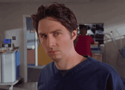 Man In Blue Scrubs Looking At Camera GIF
