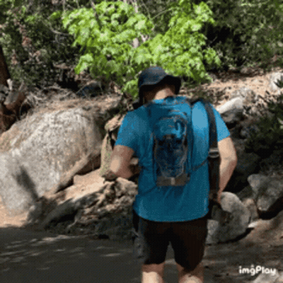 Man In Blue Shirt And Backpack Walking Trail GIF